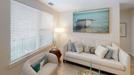 Located on N Ashley Drive in the heart of Tampa, FL 33602, this single-floor residence offers a well-appointed, modern living experience with a cohesive coastal aesthetic throughout. The open-concept kitchen is a standout feature, showcasing crisp white shaker cabinetry extending to the ceiling, dark quartz countertops, a large center island with seating, stainless steel appliances, and light wood-style flooring — a highly functional and visually striking space. The living area is bright and inviting, with large windows that draw in natural light and create an airy atmosphere. Multiple bedrooms are generously sized and carpeted for comfort, each reflecting a calm, neutral palette. The primary bedroom includes direct access to a spacious walk-in closet and an en-suite bathroom featuring a long vanity with white countertops, gray cabinetry, and wood-look tile flooring. A second full bathroom offers a tub/shower combination with white subway tile surround and matching contemporary vanity. Additional bedrooms are well-sized and naturally lit, with ceiling fans and ample closet space. Throughout the residence, consistent finishes — light flooring, neutral walls, and modern fixtures — tie the space together into a clean, move-in-ready home in one of Tampa's most desirable urban locations.
