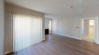 Located on Harlow Avenue in the Palms neighborhood of Los Angeles, this single-floor residence offers a clean, contemporary design with a neutral color palette throughout. The open-concept kitchen is a standout feature, equipped with stainless steel appliances including a gas range, microwave, and refrigerator, complemented by dark wood cabinetry, crisp white quartz countertops, a breakfast bar, and a striking mosaic tile backsplash in soft blue and grey tones. A double stainless steel sink sits beneath a window, allowing natural light to fill the space. The living area features hardwood-style flooring and a classic fireplace, creating a warm and inviting atmosphere. Vertical blinds on large windows allow for adjustable natural light, with views of surrounding greenery. A built-in storage cabinet near the entryway adds practical functionality. The bedrooms are carpeted for comfort and receive ample sunlight through generously sized windows. Each bathroom is appointed with modern dark wood vanities, vessel sinks, framed mirrors, and shower-tub combinations, all finished with light wood-tone flooring. The overall ambiance is bright, clean, and move-in ready, reflecting a thoughtfully updated interior design.