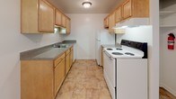 This upgraded one-bedroom, one-bathroom unit in Westland, Michigan offers a practical and well-maintained single-floor layout. The living room provides a comfortable, open feel with neutral wall-to-wall carpeting, a large window that invites natural light and outdoor views of surrounding greenery, and a baseboard heating system. The space flows seamlessly toward the kitchen and bedroom areas.

The galley-style kitchen is efficiently designed with light wood cabinetry lining both walls, offering ample storage. Laminate tile flooring, a double-basin sink with granite-look countertops, a white electric range, and a refrigerator complete the functional setup. A ceiling fan provides additional ventilation.

The bedroom is generously proportioned, featuring plush carpeting, a ceiling fan with light fixture, a large window for natural light, baseboard heating, and a dedicated closet for storage.

The full bathroom is finished with white ceramic floor and wall tiles, a tub-shower combination, a wood-toned vanity with countertop storage, and a window that allows natural light. Baseboard heating keeps the space comfortable year-round.

Overall, the unit presents a clean, neutral aesthetic with practical upgrades throughout.