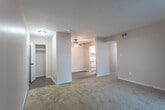 Located at 253 Clemwood Pkwy in Hampton, Virginia, this single-story unit offers a practical and straightforward layout spread across several distinct areas. The living space features neutral-toned carpet flooring and is brightened by a sliding glass door fitted with vertical blinds, allowing natural light to filter in while providing access to an outdoor view. A ceiling fan adds functionality to the adjoining area, which transitions to hard-surface flooring and connects to the main entry door.

The kitchen is laid out in a U-shaped configuration, offering ample cabinetry with white upper and lower cabinets accented by brushed nickel hardware. Light-toned laminate countertops provide generous prep space, complemented by a stainless steel double sink, an electric coil range, and a black dishwasher. Dark wood-look vinyl flooring anchors the kitchen area.

The bedrooms are carpeted and well-lit, with multiple windows offering outdoor views and natural light. One bedroom features a spacious double-door closet with built-in shelving and hanging rods. The bathroom includes a wood-framed vanity with a mirrored medicine cabinet, while a separate area houses a full-size soaking tub surrounded by classic white square tile. Warm, neutral wall tones carry throughout the entire space, creating a cohesive and understated ambiance.