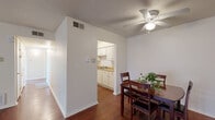 Located at 431 McCain Blvd in North Little Rock, Arkansas, this two-bedroom, three-bathroom single-floor home offers a practical and comfortable layout. Rich hardwood-style flooring runs throughout the living areas and bedrooms, lending warmth and continuity to the space. The combined dining and living area is bright and functional, featuring a ceiling fan with light fixture and an open sightline to the galley-style kitchen. The kitchen is efficiently designed with white cabinetry lining both walls, light wood-tone countertops, a double sink, and white appliances including a range and refrigerator. The dining area comfortably accommodates a dining set and includes an adjacent closet for added storage. The bedrooms are well-proportioned, each featuring hardwood-style floors, ceiling fans, and windows that invite natural light. The primary bedroom is generously sized with its own closet access. Three full bathrooms serve the home, with one featuring a soaking tub and vanity area. Additional highlights include a dedicated laundry area, utility room, hallway, and an impressive six closets throughout. Outside, the home is set in a quiet, tree-lined neighborhood with a paved parking area and a grassy yard.
