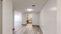 Located at 1390 East St in New Britain, CT, this single-floor residence offers two bedrooms and three bathrooms within a well-organized, functional layout. Wood-look luxury vinyl flooring runs throughout the home, lending a cohesive and modern aesthetic to every room. The open living area connects seamlessly to the kitchen, which is a standout feature of the home. The kitchen is equipped with stainless steel appliances — including a range, dishwasher, and refrigerator — complemented by granite countertops, white cabinetry with wood trim accents, and a decorative tile backsplash that adds texture and visual interest. The primary bedroom is generously sized, featuring dual closets and a window that brings in natural light. The second bedroom also offers closet storage and windows with outdoor views. Three bathrooms serve the home, each finished with wood-look flooring; the bathrooms include vanities with countertop sinks, mirrors, and at least one full bathtub. A hallway connects the private sleeping quarters to the main living areas. Textured ceilings and neutral warm-toned walls throughout create a clean, move-in-ready atmosphere suited for comfortable everyday living.