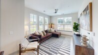 Located at 4285 Julep Way SW in Aiken, South Carolina, this thoughtfully designed 2-bedroom, 2-bathroom residence offers a comfortable and contemporary single-floor layout. The open-concept kitchen and living area serves as the heart of the home, featuring a sleek kitchen with white shaker cabinetry, a tiled backsplash, stainless steel appliances, and a large island with bar seating — ideal for both cooking and entertaining. Light wood-tone flooring flows throughout, enhancing the bright, airy feel. The living room is bathed in natural light from multiple large windows with views of the surrounding greenery, and is complemented by a modern ceiling fan overhead. Both bedrooms offer a calm, neutral palette with plush carpeting, ceiling fans, and generous natural light. The primary bedroom includes its own walk-in closet with wire shelving, while a second walk-in closet services the additional bedroom. Each bathroom is finished with white vanity cabinetry, clean tile flooring, and framed artwork. The primary bath features a glass-enclosed shower, while the secondary bath offers a shower-tub combination. The overall ambiance is modern, clean, and welcoming throughout.
