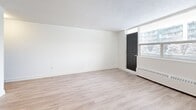 Located at 120 Dundas St E in Mississauga, this well-appointed unit offers three bedrooms, two bathrooms, a living room, dining room, kitchen, and a balcony — all on a single floor. Throughout the unit, light-toned hardwood flooring creates a clean, cohesive aesthetic that complements the crisp white walls and bright, open feel of each room.

The living and dining areas are generously proportioned, with large windows that invite natural light and offer views of the surrounding neighbourhood. The living area features a textured ceiling and baseboard heating, providing practical comfort. An open passageway connects the living and dining spaces to the kitchen, which is visible in warm-toned cabinetry.

Each of the three bedrooms is well-lit, featuring large windows with baseboard heating beneath. The primary bedroom includes mirrored sliding closet doors, enhancing the sense of space. The additional bedrooms are bright and versatile, with clean white walls and the same hardwood flooring. Distinctive dark panel doors add a modern contrast throughout the unit.

The bathrooms are finished with classic white subway tile, a mirrored medicine cabinet, and clean white fixtures, offering a timeless and functional design. The overall ambiance is bright, neutral, and move-in ready.