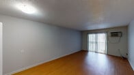 Located at 1307 Greenwood Ave in Kalamazoo, Michigan, this single-floor unit offers a straightforward, functional layout designed for comfortable everyday living. The entryway opens directly to the main living area, which features warm hardwood-style flooring and neutral gray walls beneath a textured ceiling. A sliding glass door fitted with vertical blinds allows natural light to fill the space while providing access to the outdoors.

The kitchen is efficiently arranged and equipped with dark espresso-toned cabinetry, both upper and lower, paired with laminate countertops, a stainless steel sink, an electric range, and a stainless steel dishwasher. Light tile flooring completes the practical, easy-to-maintain aesthetic of this space.

The bedroom areas are carpeted in a neutral beige tone and receive natural light through standard windows with blinds. The rooms offer clean, open wall space suitable for a variety of furniture arrangements.

The bathroom includes a full tub-shower combination with a curtain rod, a vanity with dark countertop, a mirror, and tile flooring, maintaining a clean and utilitarian design consistent throughout the unit.