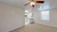 Located at 1201 N Foster Dr in Baton Rouge, Louisiana, this single-story unit offers a practical and comfortable layout designed for everyday living. The open-concept living area is carpeted and generously sized, with ceiling fans providing airflow and windows allowing natural light to filter in. This main living space flows seamlessly into the kitchen, which is separated by a peninsula counter — ideal for casual dining or meal prep. The kitchen is well-equipped with white cabinetry, a gas range, dishwasher, refrigerator, and a sink set beneath upper cabinets, all finished with tile flooring and a tasteful backsplash. The bedrooms are carpeted and spacious, each fitted with ceiling fans and windows that bring in natural light. One bedroom features a built-in closet with shelving, offering ample storage. The bathroom is thoughtfully laid out with a long vanity countertop, generous cabinet storage, a large mirror, and a separate tiled tub and shower area with tile flooring throughout. Clean neutral tones and white trim are carried consistently throughout the unit, creating a bright and cohesive feel from room to room.