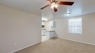 Located at 1201 N Foster Dr in Baton Rouge, Louisiana, this single-story unit offers a practical and comfortable layout designed for everyday living. The open-concept living area is carpeted and generously sized, with ceiling fans providing airflow and windows allowing natural light to filter in. This main living space flows seamlessly into the kitchen, which is separated by a peninsula counter — ideal for casual dining or meal prep. The kitchen is well-equipped with white cabinetry, a gas range, dishwasher, refrigerator, and a sink set beneath upper cabinets, all finished with tile flooring and a tasteful backsplash. The bedrooms are carpeted and spacious, each fitted with ceiling fans and windows that bring in natural light. One bedroom features a built-in closet with shelving, offering ample storage. The bathroom is thoughtfully laid out with a long vanity countertop, generous cabinet storage, a large mirror, and a separate tiled tub and shower area with tile flooring throughout. Clean neutral tones and white trim are carried consistently throughout the unit, creating a bright and cohesive feel from room to room.