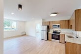 Located at 302 W Sixth St in Chattanooga, TN, this thoughtfully designed one-bedroom, one-bathroom unit offers a clean, modern aesthetic throughout its efficiently utilized floor plan. Light hardwood flooring flows seamlessly across every room, creating a cohesive and airy atmosphere.

The open-concept kitchen and living area serves as the heart of the unit. The kitchen is outfitted with warm wood cabinetry, light granite countertops, a stainless steel refrigerator, electric range, built-in microwave, and dishwasher — providing a well-equipped cooking space that integrates naturally with the adjacent living area. Recessed and flush-mount lighting illuminate the space effectively.

The living area is bright and versatile, benefiting from natural light through a window and wall-mounted climate control for year-round comfort. The bedroom is a comfortable, well-proportioned retreat featuring a wide window with outdoor views of the surrounding greenery, a dedicated closet, and continued hardwood flooring.

The full bathroom is finished with white subway tile surrounding the soaking tub and shower combination, granite-topped wood vanity with an undermount sink, a framed mirror, and recessed lighting, presenting a clean and contemporary feel throughout.