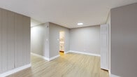 Located at 1718 W 55th Ave in Merrillville, Indiana, this single-floor, 2-bedroom, 3-bathroom home offers a clean, modern aesthetic throughout. Light-toned luxury vinyl plank flooring runs consistently across the living spaces, complementing the neutral gray walls and crisp white trim that define the interior palette.

The living room is a bright, open space featuring large vertical-blind-covered sliding glass doors that invite natural light and provide outdoor access. A vertical shiplap accent wall adds a subtle design detail to the room. Baseboard heating is present throughout.

The kitchen showcases white shaker-style cabinetry, white marble-look quartz countertops, a matching tile backsplash, and a stainless steel gas range, offering a polished, contemporary cooking space.

Both bedrooms are well-sized and comfortably proportioned, with the primary bedroom featuring a generous closet with a double hanging rod. One bedroom includes a window with natural light and a baseboard heater.

All three bathrooms are tastefully updated, featuring white vanities with undermount sinks, matte black fixtures and hardware, framed mirrors, and tub-shower combinations with tile surrounds. The home also includes a dedicated laundry area, hallway, and additional closet storage, rounding out a well-organized and efficiently designed floor plan.
