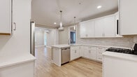 Located at 50 Mount Bethel Road in Warren, NJ, this thoughtfully designed one-bedroom, one-bathroom unit offers a clean, modern aesthetic across a well-appointed single floor. Light-toned hardwood flooring flows seamlessly throughout, unifying every room in a warm, cohesive palette of whites and soft greiges.

The open-concept kitchen and living area serves as the heart of the space. The kitchen is outfitted with crisp white shaker cabinetry, quartz countertops, a marble-style tile backsplash, and a full suite of stainless steel appliances including a gas range, built-in microwave, dishwasher, and refrigerator. A peninsula with pendant lighting above provides both additional prep space and a natural division between the kitchen and the generously sized living area. Recessed lighting and crown molding add a refined touch throughout.

The bedroom is a comfortable retreat featuring large windows that invite abundant natural light and offer tranquil outdoor views. A sliding closet provides practical storage, while the warm flooring and neutral walls create a calm, restful atmosphere.

The bathroom is well-appointed with a shaker-style vanity, quartz countertop, a combined tub and shower, chrome fixtures, and a bright window. Speckled tile flooring and soft lighting complete the polished finish. Two hallways connect the rooms efficiently, enhancing the overall flow of the layout.