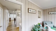 Located at 1700 RT 37 W in Toms River, NJ, this well-appointed 2-bedroom, 2-bathroom single-story home offers a thoughtfully designed layout across a comfortable footprint. The entrance features distinctive vertical shiplap-style paneling, setting a clean, cottage-inspired tone throughout.

The living room is bright and welcoming, with recessed lighting, light wood-look flooring, and large windows that invite natural light and neighborhood views. The space flows naturally into the rest of the home, providing an open and airy feel.

The kitchen is a standout feature, boasting white shaker cabinetry, marble-look countertops, white appliances, and a skylight that fills the room with additional natural light. A full-size washer is integrated directly into the kitchen, offering convenient in-unit laundry access. A window above the sink adds to the bright, functional atmosphere.

The generously sized primary bedroom features soft blue-gray walls, light wood flooring, and a large window overlooking the outdoors. The second bedroom is equally comfortable, also featuring soft tones and natural light. Both rooms benefit from the home's four closets, providing ample storage throughout.

The two bathrooms include a tiled full bath with a soaking tub and a second bath with a walk-in shower equipped with grab bars. The overall palette of soft grays, whites, and warm wood tones creates a cohesive, calm ambiance throughout the home.