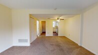 Located at 1530 Koa Dr in Springfield, Ohio, this two-floor residence offers a practical and straightforward layout with consistent finishes throughout. The main living area is generously sized, featuring neutral beige carpeting and soft yellow walls that create a warm, understated atmosphere. A ceiling fan with a light fixture anchors the space, while an open sightline connects directly to the kitchen, enhancing the sense of flow. A sliding glass door admits abundant natural light and provides outdoor access, complemented by vertical blinds for privacy. A closet with bi-fold doors adds convenient storage off the main living space.

The kitchen is efficiently arranged in an L-shaped configuration, featuring white cabinetry, warm-toned laminate countertops, a double stainless steel sink, and a white electric range. A window above the sink brings in natural light, and a dishwasher is included among the appliances.

The bedrooms are carpeted and finished in the same warm neutral palette, each with windows fitted with vertical blinds that allow for natural light and outdoor views. At least one bedroom includes a built-in closet with a hanging rod and shelf for organized storage.

The bathroom features wood-look flooring, a white vanity, and a full tub-shower combination with white tile surround, maintaining a clean and functional aesthetic throughout.