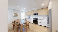 Located on Ohio Avenue in the desirable West Los Angeles neighborhood of Westwood, this modern single-floor unit offers a thoughtfully designed layout with multiple bedrooms, four bathrooms, and a dedicated laundry area. The open-plan kitchen and dining room serve as the heart of the space, featuring flat-panel light wood cabinetry extending to the ceiling, white lower cabinets, a marble-look white quartz countertop with a matte black faucet, and a full suite of stainless steel appliances including a gas range, built-in microwave, dishwasher, and french door refrigerator. Light hardwood flooring runs throughout, complemented by recessed lighting and a wall-mounted mini-split system for climate control. The dining area comfortably accommodates a full-sized table and chairs. Each bedroom is bright and airy, with large black-framed windows offering leafy outdoor views, wall-mounted mini-split units, and sliding closet systems for ample storage. The bathrooms are finished to a high standard with wave-textured white tile walls, terrazzo-style flooring, frameless glass shower enclosures, matte black fixtures, floating wood vanities, and round wall mirrors. A connecting hallway ties the layout together efficiently, completing this clean and contemporary residence.