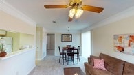 This single-floor residence at 51 Northtown Dr in Jackson, Mississippi offers a well-organized and comfortable layout designed for everyday living. The living room is a welcoming space featuring crown molding, soft carpet flooring, and a ceiling fan with light fixture. A large window fills the room with natural light, creating a bright and airy atmosphere. Adjacent to the living room, the dining area is defined by an elegant pendant light and a sliding glass door framed by vertical blinds, offering views to the outdoors and allowing additional natural light to flow through. The kitchen is efficiently designed with white cabinetry trimmed in warm wood tones, granite-style countertops, tile flooring, and white appliances including a range and refrigerator. The two bedrooms are carpeted and restful spaces, each equipped with ceiling fans and windows that bring in natural light. The primary bedroom features a textured ceiling and direct access to the bathroom. The bathroom includes a wide vanity with a single sink, a large mirror, and convenient access to a walk-in closet. Throughout the residence, neutral tones and consistent finishes create a cohesive and inviting atmosphere suited for comfortable, functional living.