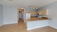 Located at 15300 Dismuke Ave in Biloxi, Mississippi, this two-floor home offers a well-organized layout with thoughtful finishes throughout. The kitchen is a functional centerpiece, featuring light wood cabinetry, warm laminate countertops, a peninsula with a double sink, and track lighting overhead. White appliances include a side-by-side refrigerator with ice maker, an electric range, and a built-in microwave. The kitchen flows seamlessly into a bright dining area adorned with a classic chandelier and large tile flooring that carries natural light across the space. Bedrooms feature warm hardwood flooring, ceiling fans, and windows with blinds that invite generous amounts of natural light while offering views of the surrounding greenery. The soft blue-gray wall tones used consistently throughout the home create a calm, cohesive atmosphere. Bathrooms are finished with tile flooring, vanities with laminate countertops, and a combination tub and shower. One bathroom features a white double-sink vanity with a large mirror, offering additional counter space. The textured ceilings and clean white trim provide a classic residential aesthetic. The doll's-eye view reveals a spacious, well-connected floor plan that balances open living areas with private spaces across both levels.