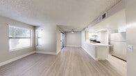 Located at 3800 S Nellis Blvd in Las Vegas, Nevada, this well-appointed one-bedroom, one-bathroom residence offers a thoughtfully designed single-floor layout. The open-concept living and dining area is bright and welcoming, featuring light wood-style flooring, neutral-toned walls, a ceiling fan, and a textured ceiling. Large windows dressed with blinds allow natural light to filter in, while a sliding glass door leads to a private balcony. The kitchen is efficiently designed with white shaker-style cabinetry, light quartz countertops, a stainless steel refrigerator, an electric range, and an under-cabinet range hood. A curved breakfast bar provides additional seating and connects seamlessly to the living and dining area. The bedroom offers comfortable carpeting, a window for natural light, and a sliding-door closet providing ample storage. The bathroom features a white vanity with quartz countertops, a large mirror, and brushed nickel fixtures. A dedicated laundry area includes full-sized washer and dryer units with overhead shelving. The overall ambiance is clean, modern, and move-in ready, with a consistent neutral palette throughout.