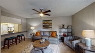 This single-floor residence offers a thoughtfully arranged layout that balances comfort and functionality across its key living spaces. The living room serves as the heart of the home, featuring plush carpeting, a ceiling fan with integrated lighting, and neutral gray walls that create a calm, inviting atmosphere. The space is well-suited for both relaxing and entertaining, with room for a full seating arrangement and accent furnishings. A window near the entry door allows natural light to brighten the area.

The bedroom is a restful retreat, outfitted with carpet flooring, a ceiling fan, and a generously sized window fitted with blinds for light control and privacy. The adjacent bathroom area includes a wide vanity with granite-style countertops, white cabinetry, a large mirror with overhead lighting, and hardwood-style flooring. A walk-in closet is conveniently accessible directly from the vanity area.

The kitchen is efficiently designed with white shaker-style cabinetry, granite-style countertops, hardwood-style flooring, and white appliances including a range and full-size refrigerator. A dedicated home office rounds out the layout, offering carpeted floors, a window with blinds, and ample space for a desk and shelving unit — ideal for productive work-from-home arrangements. Textured ceilings are present throughout the residence.