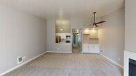 Located in Beaverton, Oregon, this two-bedroom, two-bathroom single-floor residence offers a practical and comfortable layout with clean, neutral finishes throughout. The open kitchen is a standout feature, showcasing white shaker cabinetry, stainless steel appliances including a refrigerator, range, and over-the-range microwave, a subway tile backsplash, and a light quartz countertop with an integrated sink — ideal for both everyday cooking and entertaining. The combined kitchen and living area flows naturally, with the living room anchored by a classic fireplace and sliding glass doors that open onto a private balcony, bringing in natural light and outdoor views. Both bedrooms are generously proportioned with soft, neutral carpet and light gray walls that create a calm and restful atmosphere. The primary bedroom includes direct access to an ensuite bathroom featuring a white vanity with a large mirror and a walk-in closet. The second bathroom offers a standalone shower with a glass sliding door. Baseboard heating is present throughout. The overall design is clean, understated, and move-in ready, making it a well-appointed home in a convenient Beaverton location.