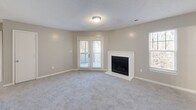 Located at 100 Bryton Trce in Columbia, SC, this single-floor, 2-bedroom, 2-bathroom home offers a well-organized layout with neutral tones and carpeted flooring throughout the main living areas. The spacious living room is a standout, featuring a white-mantled fireplace, multiple windows with blinds that invite natural light, and French doors opening to an outdoor deck. The open kitchen is equipped with gray cabinetry, a white subway tile backsplash, dark granite countertops, stainless steel refrigerator, and black appliances, complemented by wood-look flooring. A peninsula counter adds prep space and visual separation from the adjoining living area. Both bedrooms are generously sized, each with ceiling fans, plush carpet, and ample closet space. The primary bedroom benefits from additional square footage and its own closet. The two bathrooms are finished with gray vanity cabinetry, large mirrors with Hollywood-style lighting, wood-look flooring, and a tub/shower combination. A connecting hallway ties all rooms together, ensuring a functional and cohesive flow throughout the home.