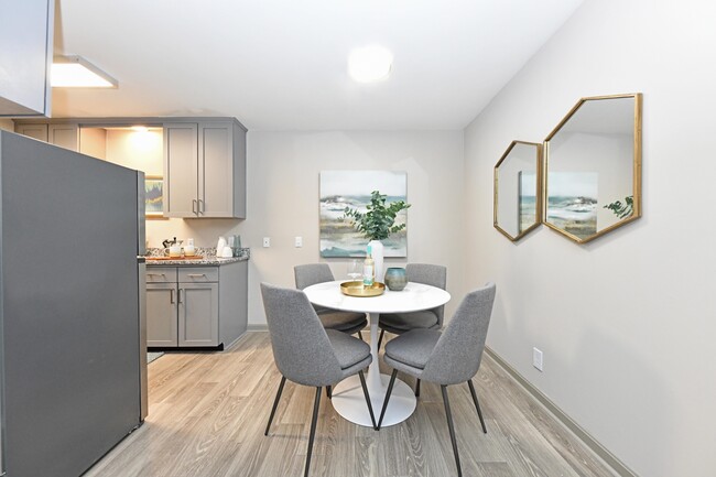 Dining area with hardwood-style flooring and overhead lighting - Kinley at the Park