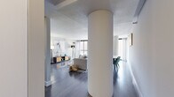 Located at 777 S State St in Chicago's South Loop neighborhood, this single-floor residence showcases a thoughtfully designed open layout defined by striking architectural cylindrical columns that serve as a visual centerpiece throughout the main living area. Dark hardwood floors flow consistently across the space, grounding the contemporary aesthetic.

The expansive living room benefits from floor-to-ceiling windows that frame panoramic city views, flooding the area with natural light. The open-concept design allows the living and dining zones to interact seamlessly, creating a generous, versatile entertaining space with clean sightlines throughout.

The kitchen features light maple cabinetry paired with dark countertops and black appliances, including a range, dishwasher, and refrigerator. Ample upper and lower cabinet storage provides practical functionality.

The primary bedroom is generously proportioned, with large windows offering elevated city views and vertical blinds for light control. A secondary bedroom provides a quieter, more intimate retreat with its own window overlooking the Chicago skyline.

Throughout the residence, neutral tones, textured ceilings, and abundant natural light contribute to a bright, modern ambiance well-suited to urban living in the heart of Chicago.