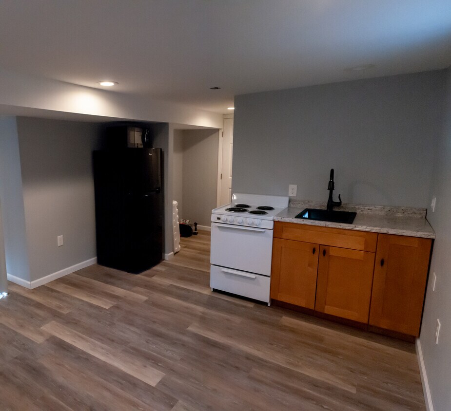 Kitchen includes over-the-counter cabinets and ducted range hood over stove. - 1000 Charles St