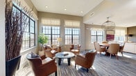 Located at 1106 Euclid Ave in Charlotte's vibrant South End neighborhood, this single-floor community lounge offers a thoughtfully designed multi-functional space with a refined, upscale ambiance. The layout seamlessly integrates a living area, dining area, and game room, each with its own distinct character while maintaining a cohesive aesthetic throughout.

The living area is anchored by an arrangement of rich cognac leather armchairs and a sleek round coffee table, all set atop a patterned area rug. Large, grid-paned windows flood the space with natural light and frame impressive views of the Charlotte skyline. Roman shades provide a soft, polished finish. A separate lounge nook features a contemporary sofa, wall-mounted flat-screen TV, and a textured wood-paneled accent wall, creating an intimate media retreat.

The dining area is centered around an elegant oval dining table paired with upholstered chairs, illuminated by a sculptural globe pendant light. Floor-to-ceiling windows continue here, reinforcing the bright, airy feel and connection to the city beyond. Access to an outdoor balcony extends the space further.

The game room rounds out the layout with a stately billiards table as its centerpiece, complemented by a dramatic crystal chandelier, bold decorative wall art, and an additional wall-mounted TV — making it an ideal space for entertainment and social gatherings.