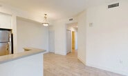 Located at 26780 SW 140th Ave in Naranja, FL, this single-floor residence offers a thoughtfully designed layout with 2 bedrooms and 2 full bathrooms. Light-toned wood-look tile flooring runs throughout, giving the space a clean, cohesive aesthetic. The open-concept kitchen and living area serves as the central hub of the home, featuring a peninsula counter with a gray top, white cabinetry, stainless steel refrigerator, and a pendant light fixture. The layout flows easily from the kitchen into the living area, which is equipped with a ceiling fan and sliding glass doors that open onto a private balcony with views of the surrounding community. Both bedrooms are bright and airy, with one offering direct balcony access and outdoor views through a large sliding door, while the second benefits from a picture window that fills the room with natural light. Each bedroom is served by a dedicated closet, including a walk-in closet with wire shelving for ample storage. The two bathrooms are finished with white tile surround tub-shower combinations and chrome fixtures. Additional spaces include a hallway, laundry area, and utility room, completing a functional and well-rounded floor plan ideal for everyday living.