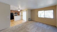 Located at 532 Broadway in El Cajon, California, this single-story unit offers a practical and comfortable layout designed for everyday living. The open-concept living and dining area is generously sized, featuring plush carpeting, warm neutral-toned walls, and a ceiling fan overhead. Natural light filters in through windows dressed with vertical blinds, creating a bright and welcoming atmosphere. A built-in wall unit adds convenient storage to the living space.

The kitchen is open to the living area via a breakfast bar counter finished with granite-look laminate surfaces. Rich wood-toned cabinetry extends to the ceiling, providing ample storage, while black appliances — including a refrigerator, electric range, and over-the-range microwave — give the kitchen a cohesive, modern look. Light hardwood-style flooring anchors the kitchen and extends into the entryway.

The bedrooms are carpeted and well-proportioned, each featuring ceiling fans with light fixtures and windows that allow natural light to flow in. The rooms offer a calm, neutral aesthetic that adapts easily to a variety of uses. The bathroom includes a clean, white tub-shower combo with a simple, functional design. Throughout the unit, the consistent use of soft wall tones and neutral finishes creates a cohesive and move-in-ready environment.