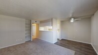 Located at 4629 W Walnut St in Garland, TX, this one-bedroom, one-bathroom unit offers a functional and well-organized single-floor layout. The open-concept living, dining, and kitchen area forms the heart of the home, with a pass-through kitchen counter that connects the spaces seamlessly. The living area features plush carpeting, a ceiling fan with light, and built-in open shelving along one wall — ideal for display or storage. The kitchen is laid out in a galley style with white cabinetry, marble-patterned countertops, a double-basin sink, and white appliances including a refrigerator and stovetop, complemented by dark wood-look flooring. A pantry provides additional kitchen storage. The bedroom is a comfortable size, carpeted, and includes a ceiling fan, a window with natural light, and access to three closets — one of which is a walk-in with dual hanging rods. The bathroom features a vanity with a marble-patterned countertop, wood-look flooring, and a full tub-shower combination with white tile surround. A hallway connects the private areas of the unit. Textured ceilings are consistent throughout, and neutral wall tones create a clean, move-in-ready aesthetic.