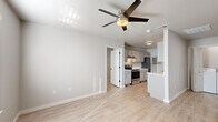 Located at 603 SW Sapphire Dr in Bentonville, Arkansas, this single-story, 3-bedroom, 2-bathroom home offers a functional and efficiently designed layout. Light wood-look flooring runs consistently throughout the space, lending a cohesive and modern feel to every room.

The living room provides a comfortable gathering area, featuring a ceiling fan with light fixture and a window with blinds that allow natural light to filter in. It connects openly to the kitchen, which is laid out in a galley style with gray cabinetry lining both sides, white quartz-style countertops, a stainless steel sink, and a full suite of stainless steel appliances including a range, refrigerator, and dishwasher.

The primary bedroom is a well-proportioned retreat with a ceiling fan, windows with horizontal blinds, and direct access to a hallway leading to additional rooms and bathrooms. The two additional bedrooms are bright, neutrally finished rooms with windows and ceiling fans, suitable for a variety of uses.

Both bathrooms are identical in design, each featuring a white soaking tub and shower combination, a round mirror, a white vanity, and brushed nickel hardware. Neutral gray walls and wood-look flooring complete the clean, contemporary look throughout this well-appointed Bentonville home.