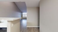 This contemporary townhouse in Towson, MD offers 1540 square feet of living space across two floors. The ground floor spans 940 square feet, while the upper level provides 600 square feet. The home features two bedrooms, including a spacious 180 square foot primary bedroom, and three full bathrooms.

The interior is characterized by its modern design and abundance of natural light. Large windows, some with transom details, flood the rooms with sunlight and offer views of the surrounding area. The flooring throughout is a stylish wood-look material, providing a cohesive and contemporary feel.

The kitchen is a standout feature, boasting light gray cabinetry, white countertops, and black appliances, including a built-in microwave and electric range. The layout is efficient, with ample counter and storage space.

Bathrooms are well-appointed with modern fixtures, including vanities with undermount sinks and glass-enclosed showers. Some bedrooms feature plush carpeting for added comfort.

The home's open concept design is evident in the living areas, which flow seamlessly into one another. A staircase with wooden railings connects the two floors, adding to the home's architectural interest.

Overall, this townhouse offers a blend of contemporary style, comfortable living spaces, and modern amenities in a desirable Towson location.