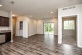 Located at 5719 NW 57th Ave in Johnston, Iowa, this single-floor, 3-bedroom, 2-bathroom home offers a well-designed layout with modern finishes throughout. The open-concept living area is bright and spacious, featuring wood-look luxury vinyl plank flooring, recessed lighting, and neutral toned walls that create a clean, contemporary feel. A large sliding glass door floods the living room with natural light while providing direct views of the surrounding greenery outdoors.

The kitchen is outfitted with dark espresso cabinetry, granite countertops, and stainless steel appliances, including a dishwasher and refrigerator. It opens seamlessly into the main living area, making the space functional and social.

All three bedrooms are carpeted and offer a quiet, comfortable retreat. The primary bedroom is a well-proportioned space that connects to a private bathroom, which features dark wood vanity cabinetry with granite countertops and wood-look LVP flooring. A dedicated closet adds practical storage. The second full bathroom mirrors the same design aesthetic, complete with a full tub and shower combination.

Additional highlights include a hallway connecting the bedroom wing, a dedicated closet for storage, and consistent neutral finishes that lend a cohesive, move-in-ready quality to the entire home.