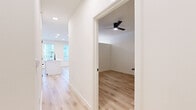This thoughtfully designed one-bedroom, one-bathroom residence in Round Rock, Texas offers a clean, modern aesthetic throughout its efficiently laid-out single floor. Light wood-style flooring flows seamlessly across every room, creating a warm and cohesive feel that complements the crisp white walls and bright, airy atmosphere.

The open-concept kitchen and living area serves as the heart of the home. The kitchen is outfitted with sleek flat-front white cabinetry, a striking marble-look tile backsplash, a stainless steel refrigerator, a slide-in range with a wall-mounted range hood, and a built-in microwave. A central kitchen island with a white countertop provides additional prep space and a natural gathering point. Recessed lighting and large windows with blinds allow natural light to fill the space.

The bedroom features a vaulted ceiling with a black ceiling fan, adding architectural interest and enhancing the sense of openness. A dedicated closet provides practical storage.

The bathroom is finished with large-format light grey tile surrounding a soaking tub and shower combination, accented by matte black hardware, and complemented by a white vanity and wood-style flooring. Additional conveniences include a dedicated laundry area and an exterior door with sidelight window offering outdoor access and added natural light.