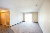 This single-floor unit offers a practical and comfortable layout designed to maximize functionality throughout. The kitchen is a standout feature, outfitted with warm honey-toned wood cabinetry, dark granite-style countertops, and a full suite of stainless steel appliances including a refrigerator, electric range, microwave, and dishwasher. Light wood-style flooring runs through the kitchen, adding a clean, modern touch.

The living area is generously sized, featuring plush carpeting, a textured ceiling, and a sliding glass door that invites natural light and provides access to an outdoor space with views of surrounding greenery. Built-in closet storage is conveniently located nearby.

Multiple bedrooms are spread throughout the unit, each finished with soft wall-to-wall carpeting, neutral walls, and windows fitted with horizontal blinds that allow for adjustable natural light. One bedroom includes direct access to an en-suite bathroom as well as a dedicated closet.

The bathrooms are well-equipped, each featuring a full soaking tub and shower combo, toilet, and vanity. The primary bathroom includes a wood-framed mirror and dark countertop, while both bathrooms are finished with wood-look vinyl flooring, offering durability and easy maintenance throughout.