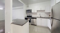 Located on the 19th floor at 2460 Weston Road in Toronto, this one-bedroom, one-bathroom unit offers a well-organized layout across a comfortable footprint. The kitchen is a standout feature, equipped with stainless steel appliances including a refrigerator, electric range, over-the-range microwave, and dishwasher. Crisp white cabinetry, a classic subway tile backsplash, dark countertops, and light tile flooring give the kitchen a clean, modern aesthetic. A peninsula counter provides additional prep space and connects the kitchen to the open-concept dining and living area. The living and dining space features polished parquet hardwood flooring that adds warmth and character throughout. Large windows allow natural light to fill the room, while a baseboard heating system ensures year-round comfort. The bedroom is a generous size, complete with mirrored sliding closet doors and the same rich parquet flooring. A private balcony extends the living space outdoors, offering expansive views of the Toronto skyline and surrounding neighbourhoods. The bathroom is finished with full subway tile surround and a soaker tub, maintaining the consistent, clean design found throughout the unit.