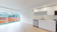 Located at 1470 Queen Street in Halifax, this modern one-bedroom, one-bathroom unit offers a thoughtfully designed open-concept layout finished with light hardwood flooring and crisp white walls throughout. The living area is bright and airy, benefiting from large floor-to-ceiling sliding glass doors that open to an outdoor space, flooding the interior with natural light and providing direct access to the exterior.

The kitchen is a standout feature, showcasing sleek, high-gloss white cabinetry, a striking marble-look tile backsplash, light quartz countertops, and a full suite of stainless steel appliances including a dishwasher, electric range, over-the-range microwave, and a bottom-freezer refrigerator. The design is clean and contemporary, maximizing both style and function.

The bedroom is a well-proportioned retreat featuring light hardwood floors, recessed lighting, and a sliding glass door that opens to the outdoor area, as well as a dedicated closet for ample storage. An additional closet provides further organization options.

The bathroom is finished in neutral tones with large-format tiles, a frameless glass walk-in shower, a floating white vanity with an integrated sink, and a full-width mirror. Every detail reflects a modern, refined aesthetic, making this a polished and efficient urban residence.