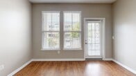 Located at 355 Amistead Ave in Fort Mill, South Carolina, this single-floor residence offers a well-designed layout with contemporary finishes throughout. The kitchen is a standout feature, showcasing light wood-tone cabinetry, granite countertops, a classic subway tile backsplash, and a full suite of stainless steel appliances, including a range, microwave, refrigerator, and dishwasher. A pendant light accent and undermount sink with a matte black faucet add modern character to the space. Wood-look flooring flows throughout the main living and kitchen areas, lending warmth and continuity. The living area benefits from multiple large windows and a glass-panel exterior door, filling the space with natural light and offering views of the surrounding neighborhood. Bedrooms are carpeted for comfort and include ceiling fans, generous windows, and walk-in closets with built-in shelving. The primary bathroom features a double vanity with granite countertops, dual matte black faucets, framed mirrors with industrial-style lighting, and a walk-in shower. A secondary bathroom provides a single-sink vanity with matching granite counters and a full tub-shower combination. Neutral wall tones and clean white trim throughout create a cohesive, move-in-ready aesthetic.