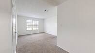 Located at 1805 IH-35 N in San Marcos, TX, this single-story, two-bedroom, two-bathroom residence offers a functional and straightforward layout designed for comfortable everyday living. The galley-style kitchen features dark cabinetry, white countertops, a double sink, and black appliances, with wood-look vinyl flooring that adds a clean, modern touch. Both bedrooms are carpeted and include ceiling fans and large windows that allow ample natural light to fill each room. The primary bedroom offers a generous footprint, providing comfortable space for furnishings. A hallway connects the main living areas and includes a closet for additional storage. The two full bathrooms mirror one another in design, each featuring dark cabinetry with white countertops, a vanity mirror, wood-look vinyl flooring, and a tub/shower combination. Textured ceilings are consistent throughout the unit, and crisp white walls create a neutral, versatile backdrop. The overall layout is efficient and well-organized, making practical use of the available space. This residence offers a clean, move-in-ready environment in a convenient San Marcos location with easy access to IH-35.