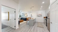 Located at 1506 Powell St in Springdale, Arkansas, this well-appointed one-bedroom, one-bathroom unit offers a thoughtfully designed layout across a single floor. Light wood-style flooring flows seamlessly throughout, creating a cohesive and airy aesthetic. The open-concept kitchen and living area serves as the heart of the home, featuring gray shaker cabinets, white quartz countertops, stainless steel appliances, a central island with pendant lighting, and direct sightlines into the spacious living room. The living room is bathed in natural light through large windows with blinds, and includes a ceiling fan for added comfort. A dedicated office provides a private workspace complete with a closet and ceiling fan, ideal for remote work or study. The bedroom is a calm retreat with multiple windows, a ceiling fan, and generous proportions. The full bathroom is finished with a gray shaker vanity, white quartz countertop, a large mirror, gold-toned light fixtures, and wood-style flooring. In-unit laundry is also included, adding everyday convenience. Clean white walls and recessed lighting throughout contribute to the bright, modern ambiance of this well-designed Springdale residence.
