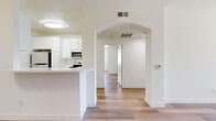 Located at 9850 Zelzah Ave in the Porter Ranch neighborhood of Los Angeles, this well-appointed two-bedroom, two-bathroom residence offers a clean and modern living environment across a single, thoughtfully laid-out floor. Light-toned wood flooring runs consistently throughout the unit, creating a bright and cohesive aesthetic in every room.

The open living room provides a generous, versatile space filled with natural light, flowing seamlessly toward the entry hallway. The kitchen features white cabinetry and stainless steel appliances, including a full-size refrigerator.

The spacious primary bedroom is a standout, offering mirrored sliding closet doors that enhance the sense of space, a large window with vertical blinds for natural light control, and direct access to its own private bathroom. The en-suite bathroom includes a tub-shower combination with a sliding frosted glass enclosure. The second bedroom is also well-sized, benefiting from its own large window that brings in ample sunlight.

The second bathroom mirrors the first in design, featuring a tub-shower with a sliding glass door, a single vanity with white cabinetry, and matching wood-style flooring. The hallway connects all rooms efficiently, completing this functional and neatly presented home.
