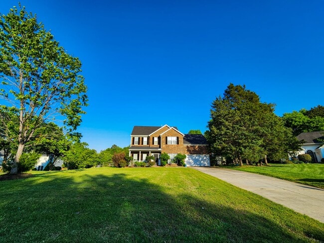 Full front view with long driveway and spacious front lawn. - 7801 Peach Blossom Ct