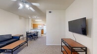 Located at 1805 Loftway Cir in Orlando, FL, this one-bedroom, one-bathroom unit offers a practical and functional single-floor layout. The open-concept main living area seamlessly combines the living room, dining room, and kitchen into one connected space. The living room features carpet flooring, a ceiling fan with integrated lighting, a wall-mounted flat-screen TV, and a window that allows natural light to filter in. The galley-style kitchen is efficiently designed with warm wood cabinetry, dark countertops, a double-basin sink, electric range, dishwasher, refrigerator, and microwave — all set on tile flooring. A dining area sits between the kitchen and living space, providing a dedicated spot for meals. The bedroom is a cozy, carpeted room with a window offering natural light and closet access. Three closets throughout the unit provide ample storage. The bathroom includes a single-sink vanity with wood cabinetry and dark countertop, a tiled tub-shower combo, and tile flooring. Additional practical features include a dedicated laundry area and a utility room, making this unit a well-rounded and efficiently organized living space.