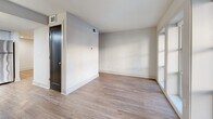 Located at 1659 Monroe Drive NE in Atlanta's sought-after Virginia-Highland neighborhood, this one-bedroom, one-bathroom unit offers a thoughtfully designed layout that maximizes every square foot. Light wood-tone flooring flows consistently throughout, creating a cohesive and clean aesthetic across the entire space.

The open-concept living, dining, and kitchen area serves as the heart of the unit. A bank of large windows flanking the front entry door floods the living area with natural light and provides street-level views. The kitchen is well-appointed with light gray cabinetry, granite countertops, a classic white subway tile backsplash, and a full suite of stainless steel appliances including a refrigerator, electric range, over-the-range microwave, and dishwasher. Pendant lighting above the peninsula counter adds a modern touch and defines the dining area.

The bedroom is a comfortable, private retreat featuring a sliding glass closet door and its own window for natural light. A dedicated closet provides practical storage. The layout also includes a full bathroom. Crisp white walls and clean lines throughout give the unit a fresh, modern feel well-suited for everyday living in one of Atlanta's most walkable and dynamic neighborhoods.