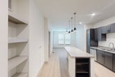 Located at 6131 Louetta Road in Spring, TX, this one-bedroom, one-bathroom unit offers a well-designed, efficient layout with modern finishes throughout. The open-concept living and kitchen area is anchored by a spacious granite-topped island with built-in storage, illuminated by a trio of stylish pendant lights. The kitchen is fully equipped with dark espresso shaker cabinets, granite countertops, and a full suite of stainless steel appliances, including a refrigerator, range, microwave, and dishwasher. Light wood-tone flooring runs throughout the main living area, enhancing the bright, clean aesthetic created by white walls and recessed lighting. The bedroom features plush carpet flooring and two windows fitted with blinds that allow for ample natural light. It connects directly to a dedicated closet, providing convenient storage. The bathroom offers a clean, tiled walk-in shower with classic white subway tile and brushed nickel fixtures. Built-in open shelving in the living area adds functional storage and display space. The overall design is contemporary and cohesive, making efficient use of every square foot for comfortable everyday living.
