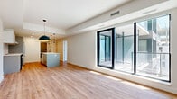 Located at 600 Mountaineer Private in Ottawa, this thoughtfully designed one-bedroom, one-bathroom unit offers a contemporary living experience across a single, well-organized floor. The open-concept living, dining, and kitchen area forms the heart of the unit, finished with warm light wood flooring that flows seamlessly throughout. The modern kitchen is a standout feature, centered around a spacious island with a white quartz countertop, undermount sink, and stylish pendant lighting. Cabinetry in soft grey tones pairs with stainless steel appliances, including a range, refrigerator, and dishwasher, complemented by a subtle tile backsplash. Large floor-to-ceiling sliding glass doors flood the living area with natural light and provide direct access to a private balcony with glass railings. The bedroom is a bright, comfortable retreat, featuring its own large window with outdoor views and generous proportions. A versatile den offers additional flexible space, ideal for a home office or secondary lounge area. The unit also includes a full bathroom, two closets, a dedicated laundry area with stacked Whirlpool washer and dryer, and a utility room, ensuring practical convenience throughout.