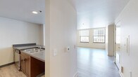 Located in the heart of Kansas City, MO, this two-bedroom, one-bathroom unit offers a well-organized single-floor layout designed for comfortable urban living. The open-concept kitchen and living area serve as the central hub of the space, where rich dark wood cabinetry, a peninsula with bar-height countertops, stainless steel appliances, and recessed lighting combine to create a functional yet stylish environment. Light wood-style hard flooring runs throughout the main living areas, lending a clean and modern aesthetic.

The living area is generously proportioned, with large windows that invite abundant natural light and frame views of the surrounding downtown Kansas City skyline. Both bedrooms are carpeted for comfort, each featuring multiple windows with views of the city's historic architecture. The primary bedroom offers a spacious footprint with dual windows, while the second bedroom is equally well-lit and versatile.

The full bathroom is thoughtfully appointed with a rich wood vanity, a large mirror, and accessibility features including grab bars, reflecting both practicality and inclusive design. A dedicated closet provides additional storage. The unit's neutral color palette, modern finishes, and downtown location make it a compelling urban residence.