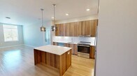 This well-appointed 3-bedroom, 2-bathroom residence at 400 W Swedesford Rd in Berwyn, PA offers a thoughtfully designed single-floor layout with generous living space. The open-concept kitchen and living area serves as the heart of the home, featuring warm wood-toned cabinetry that extends to the ceiling, a large center island with a crisp white quartz countertop, stainless steel appliances, and stylish pendant lighting — all set atop light hardwood-style flooring that flows throughout the main living areas. The living room is bright and airy, benefiting from multiple large windows with views of the surrounding greenery. The spacious primary bedroom includes a walk-in closet outfitted with wire shelving and hanging rods on multiple walls, providing excellent storage capacity. The secondary bedrooms are carpeted and well-lit with natural light from sizable windows. Both bathrooms are finished in a clean, modern aesthetic with wood-vanity cabinetry, white quartz countertops, and large LED-backlit mirrors; one features a soaking tub/shower combo, the other a walk-in shower. A dedicated in-unit laundry room with full-size washer and dryer adds everyday convenience. Throughout the residence, neutral tones and consistent finishes create a cohesive, move-in-ready living environment.