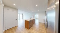 Located at 955 Eleventh Avenue in the heart of San Diego, this modern 3-bedroom, 2-bathroom residence offers a thoughtfully designed single-floor layout with a clean, contemporary aesthetic throughout. Light wood-style flooring flows seamlessly across the entire space, complementing the crisp white walls and creating a bright, cohesive ambiance.

The open-concept kitchen and living area serves as the heart of the home. The kitchen is outfitted with a large center island featuring a light quartz countertop and an undermount sink, warm wood cabinetry, stainless steel appliances including a refrigerator, range, and microwave, and recessed lighting overhead. The living area opens directly from the kitchen, with floor-to-ceiling windows and sliding glass doors that flood the space with natural light and frame sweeping views of the San Diego skyline and cityscape below.

Each of the three bedrooms continues the light, airy feel, with large windows offering impressive elevated city views. The primary bedroom provides a comfortable, well-proportioned retreat.

The two bathrooms are finished with marble-style tile surrounds in the tub-shower combinations, warm wood vanities, undermount sinks, and illuminated mirror cabinets, delivering a clean and refined look. This residence balances modern design with functional living in a prime San Diego location.