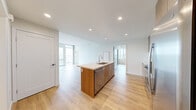 Located at 955 Eleventh Avenue in the heart of San Diego, this modern 3-bedroom, 2-bathroom residence offers a thoughtfully designed single-floor layout with a clean, contemporary aesthetic throughout. Light wood-style flooring flows seamlessly across the entire space, complementing the crisp white walls and creating a bright, cohesive ambiance.

The open-concept kitchen and living area serves as the heart of the home. The kitchen is outfitted with a large center island featuring a light quartz countertop and an undermount sink, warm wood cabinetry, stainless steel appliances including a refrigerator, range, and microwave, and recessed lighting overhead. The living area opens directly from the kitchen, with floor-to-ceiling windows and sliding glass doors that flood the space with natural light and frame sweeping views of the San Diego skyline and cityscape below.

Each of the three bedrooms continues the light, airy feel, with large windows offering impressive elevated city views. The primary bedroom provides a comfortable, well-proportioned retreat.

The two bathrooms are finished with marble-style tile surrounds in the tub-shower combinations, warm wood vanities, undermount sinks, and illuminated mirror cabinets, delivering a clean and refined look. This residence balances modern design with functional living in a prime San Diego location.